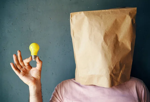 Человек Бумажным Пакетом Голове Держит Лампочку Руке Концепция Идеи Инновациями — стоковое фото