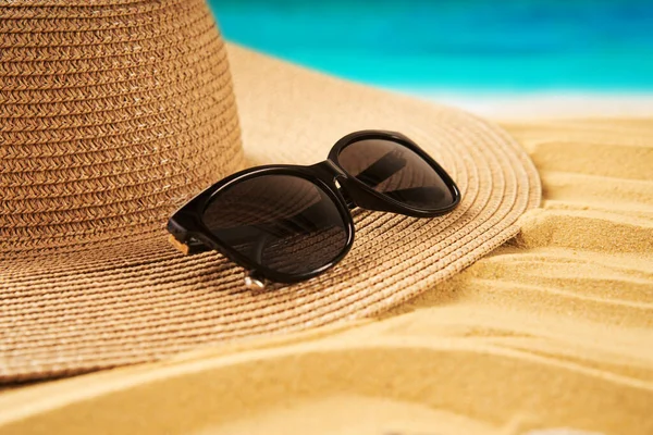 夏休みのコンセプト 麦藁帽子 砂浜と海の背景に貝殻 — ストック写真