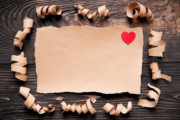濃い木製の背景に赤い紙の心を持つ紙の破片 ラブレター グリーティングカード 招待状モックアップ フラットレイアウト トップビュー コピースペース — ストック写真