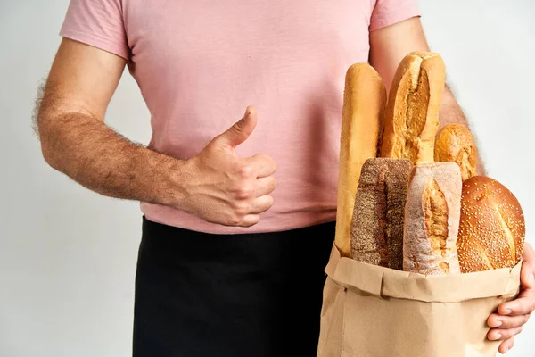 Człowiek Trzyma Świeże Bochenki Chlebowych Bagietek Papierowej Torbie Jasnym Tle — Zdjęcie stockowe