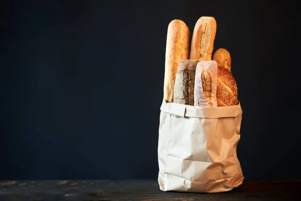 不同类型的法国面包面包面包在纸袋在黑暗的背景与复制空间 面包店 美味食品概念 — 图库照片