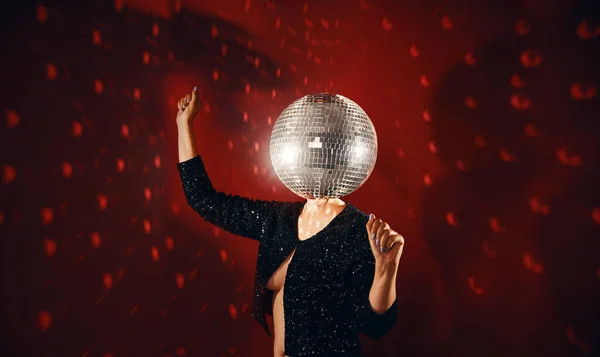 Woman in sequin dress with disco ball instead of head dancing at a party. Retro music, disco concept. Conceptual, contemporary art collage