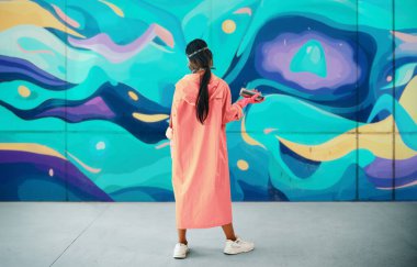 Duvara resimleriyle bakan grafiti ressamının arka görüntüsü. Sokak sanatı kavramı