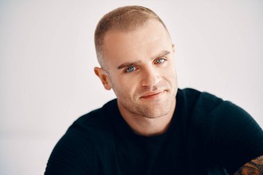 Yakışıklı bir gencin beyaz arka planına bakan yakın plan portresi.