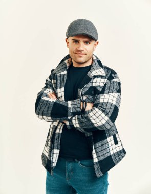 Yumuşak beyaz arka planda, tüvit şapkalı şık bir adam. Peaky Blinders stili ilham