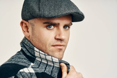 Tüvit şapkalı modaya uygun beyaz arka planda fotokopi alanı olan bir adam. Peaky Blinders stili ilham