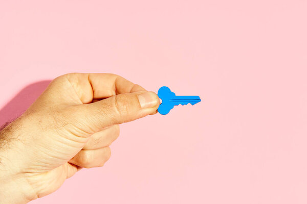 Man Hand Holding Blue Key Pink Background Copy Space Royalty Free Stock Images