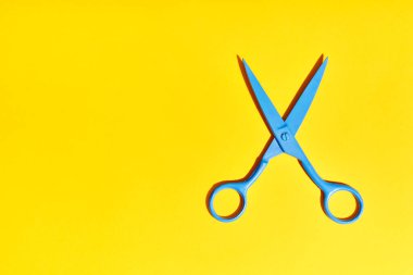 Parlak mavi makas sarı arkaplanda fotokopi alanı ile. Düz yatıyordu