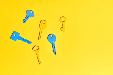 Fotokopi alanı olan canlı sarı arkaplanda çeşitli renkli anahtarlar. Düz yatıyordu