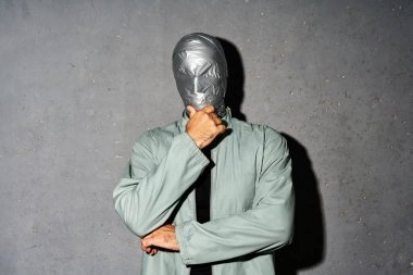 Koli bandı takmış gizemli düşünceli bir adam. Gri arka plan üzerinde çenesi olan düşünceli bir adam.