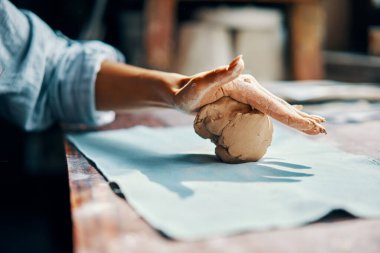 Atölyesindeki kilden kadın çömlekçi heykelleri. Çiğ kil şekillendirme işlemi yakın plan. Çömlekçilik seramiğinde ustalaşmak