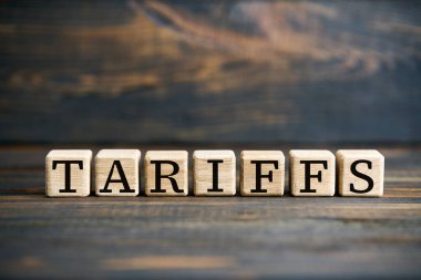 Kaba ahşap zemin üzerinde tahta bloklar üzerinde kelime TARIFFS. Ekonomik ticaret, finans kavramı.