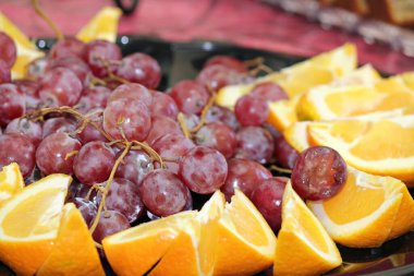 Close-up of a fruit platter with grapes surrounded by orange slices