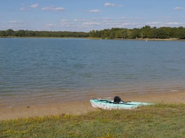 Green-white kayak boat shored beside a lake