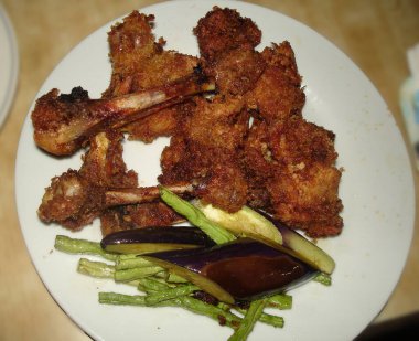 Patlıcan ve taze fasulyeyle servis edilen kızarmış tavuk budu.