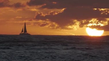 Hawaii tropikal plajında yelkenli ile gün batımının el kamerasıyla çekilmiş görüntüleri. 