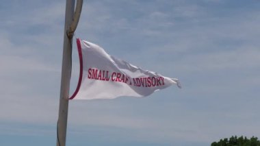 Bir direğe bağlanmış ve rüzgarda sallanan Küçük Sanatçılar Danışmanı beyaz bayrak