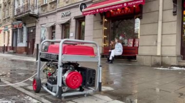 Lviv, Ukrayna - DEC 21, 2022: Kafe dışında çalışan elektrik jeneratörü, Rusya 'nın Ukrayna enerji altyapısına yaptığı büyük hava saldırıları sonrasında planlanan elektrik kesintilerinden geçiyor..