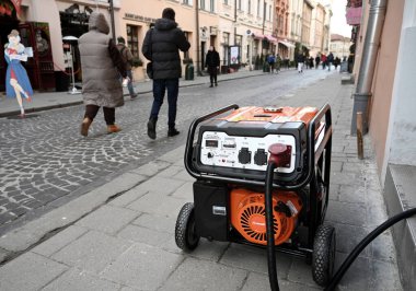 Lviv, Ukrayna - 29 Aralık 2022: Rus füze saldırısının ardından elektrik kesintisi sırasında bir mağazanın önünde bir elektrik jeneratörü.