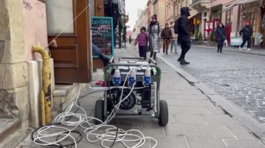 Lviv, Ukrayna - 29 Aralık 2022: Ukrayna enerji altyapısına yapılan Rus hava saldırıları sonrasında, şehir planlanan bir elektrik kesintisinden geçerken, kafenin dışında bir elektrik jeneratörü çalışıyor.