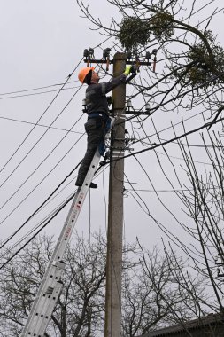 Velyka Vilshanytsia, Ukrayna - 9 Mart 2023: Bir işçi Lviv bölgesindeki Rus füze saldırısının ardından bir elektrik hattını onardı.