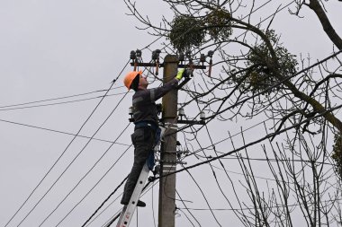 Velyka Vilshanytsia, Ukrayna - 9 Mart 2023: Bir işçi Lviv bölgesindeki Rus füze saldırısının ardından bir elektrik hattını onardı.