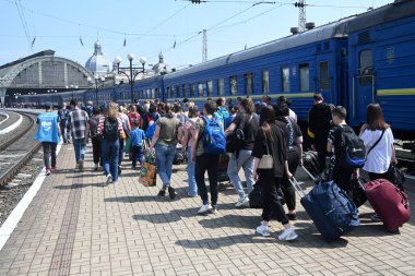 Lviv, Ukrayna - 25 Mayıs 2022: Tahliye edilenler, Lviv kentindeki tren istasyonuna vardıktan sonra bir platform boyunca yürüyorlar.