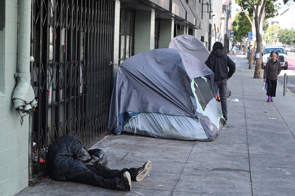  San Francisco, CA, USA - July 26, 2023:  A homeless man sleep on the street in downtown of San Francisco.