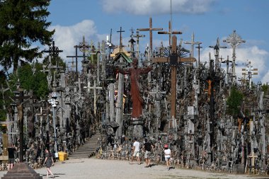 Siauliai, Lithuania - July 22, 2024: A people visiting the Hill of Crosses (Kryziu kalnas). Hill of Crosses is a major site of Catholic pilgrimage in Lithuania. clipart