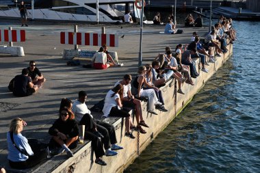 Kopenhag, Danimarka - 31 Temmuz 2024: Güneşli bir günde bir halk Kopenhag kıyısı kanalında dinleniyor.