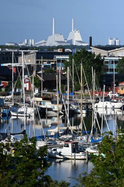 Copenhagen, Denmark - August 1, 2024: Yachts and boats in the canal and Orsted A/S Power Plant at the background. Orsted A/S is a Danish multinational energy company. clipart