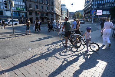 Helsinki, Finlandiya - 25 Temmuz 2024: Helsinki caddesinde bisiklet süren bir halk