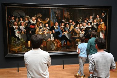 Amsterdam, Hollanda - 26 Ağustos 2024: Rijksmuseum 'da Bartholomeus van der Helst' in 1648 tarihli Munster Barışı Kutlamasında Amsterdam Sivil Muhafızları Şöleni yakınlarındaki ziyaretçiler.