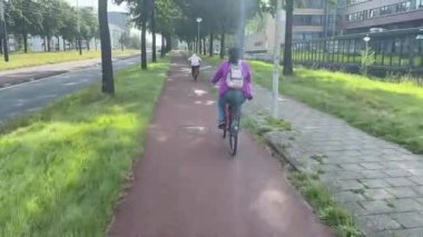 Amsterdam, Hollanda - 27 Ağustos 2024: Amsterdam caddesinde bir halk bisiklete biniyor.