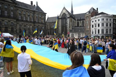 Amsterdam, Hollanda - 24 Ağustos 2024: Amsterdam 'ın merkezinde Ukrayna' nın Bağımsızlık Günü kutlamaları sırasında insanlar Ukrayna bayrakları taşıyor