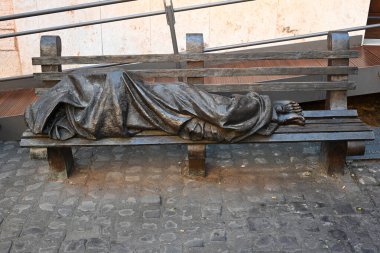 Roma, İtalya - 31 Ekim 2024: Timothy Schmalz 'ın Evsiz İsa heykeli Evsiz İsa' yı evsiz olarak tasvir ediyor, Trastevere bölgesinde Roma 'da bir bankta uyuyor..