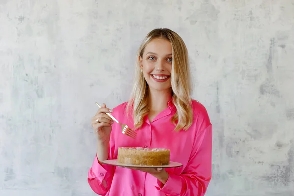 Lächelnde Blonde Frau Pinkfarbener Bluse Hält Vor Grauem Hintergrund Käsekuchen — Stockfoto
