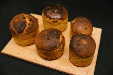 Siyah arka planda tahta bir tahtaya süslenmemiş taze Paskalya pastaları. Paskalya pastaları soğur..