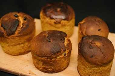 Siyah arka planda tahta bir tahtaya süslenmemiş taze Paskalya pastaları. Paskalya pastaları soğur..