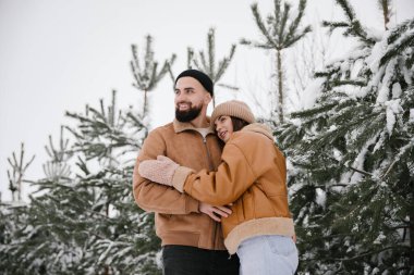 Kahverengi ceketli çift kışın sarılıyor. Kapat..