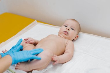 Çocuk doktoru, bebeğini muayene ediyor. Çocuğun kalp atışlarını dinlemek için steteskop kullanan bir doktor. Kapat..