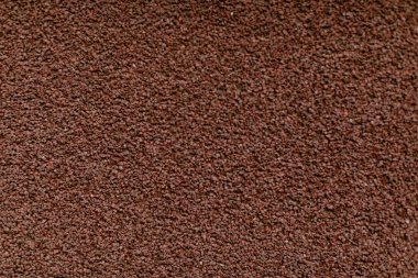 Küçük koyu kahverengi çakıl taşlarının detaylı bir yakın çekim dokusu. Eşit olarak yayılmış, engebeli ve topraksı bir his yaratıyor. Arkaplan ve inşaat temaları için ideal..