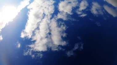 Mavi gökyüzü ve beyaz bulutlarla güneşli bir gün.