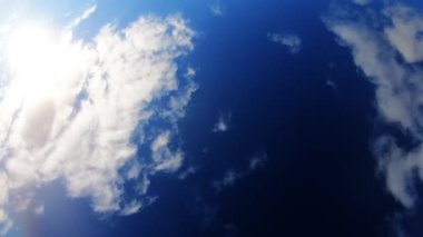 Mavi gökyüzü ve beyaz bulutlarla güneşli bir gün.