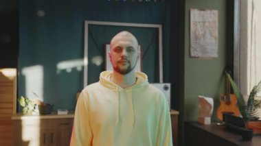 Sosyal medya üzerinde etkili biri. Genç adam iç mekanın arka planında duruyor. Adam Duygusuz Duruyor.