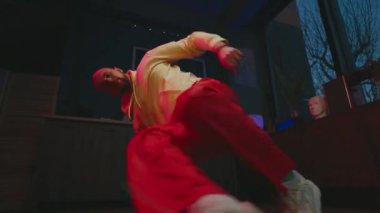 Sosyal medya üzerinde etkili biri. Neşeli genç adam kameranın önünde dans ediyor. Adam yerde break dans yapıyor..