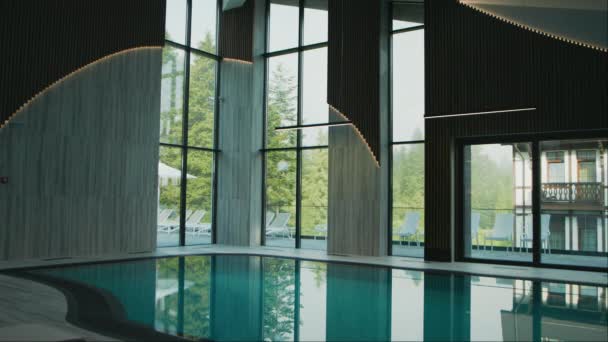 グレートプール インサイドホテル シックインテリア 透明な表面を通したサンベッドの眺め — ストック動画