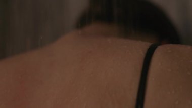 Genç Esmer 'in Arkası. Sırtından aşağı su akıyor. Kız kendini duşta yıkıyor..