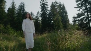 Ormanın ortasında, beyazlar içinde esmer bir kadın. Uzun saçlı genç ve güzel bir kız. Güzel güneşli bir gün. Özgürlük ve Doğayla İlişki Konsepti.