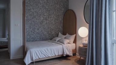 Şık ve sakin yatak odası tasarımı sessiz renkler, modaya uygun modern mobilyalar ve yumuşak ışıklandırma sergiliyor.